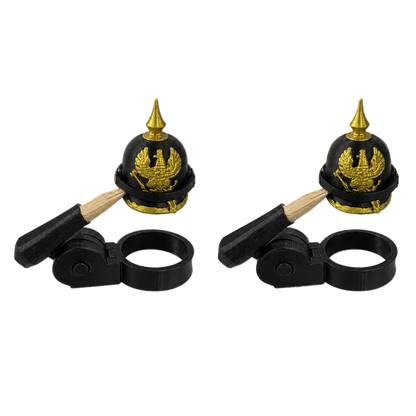 Two black and gold helmet-shaped objects with wooden handles on a white background