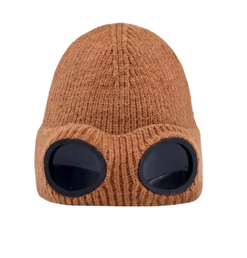 A brown ribbed knit beanie hat with two large black oval visor-like details on the front, shown against a plain white background.