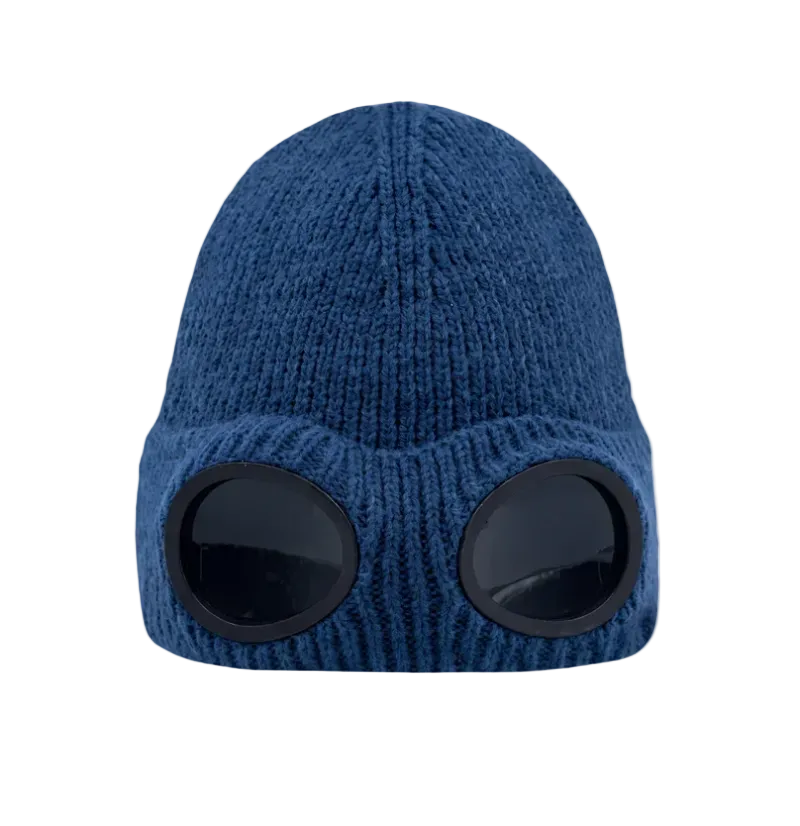 A blue ribbed knit beanie hat with two large black oval visor-like cutouts on the front, shown against a plain white background.